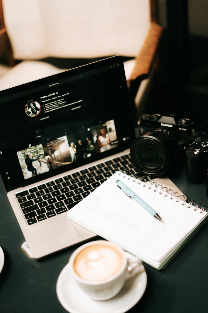 Pracovní stůl – notebook, fotoaparát, zápisník a káva